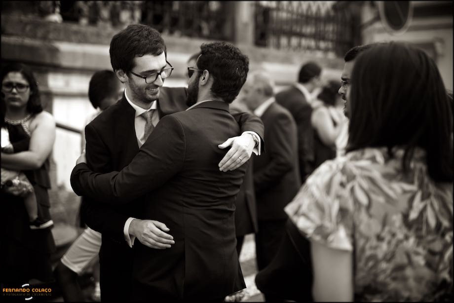 O noivo abraçando um convidado na frente da igreja depois da cerimónia no Alentejo.