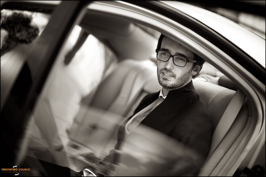 Sentado no automóvel, o noivo olha para fora, num momento.