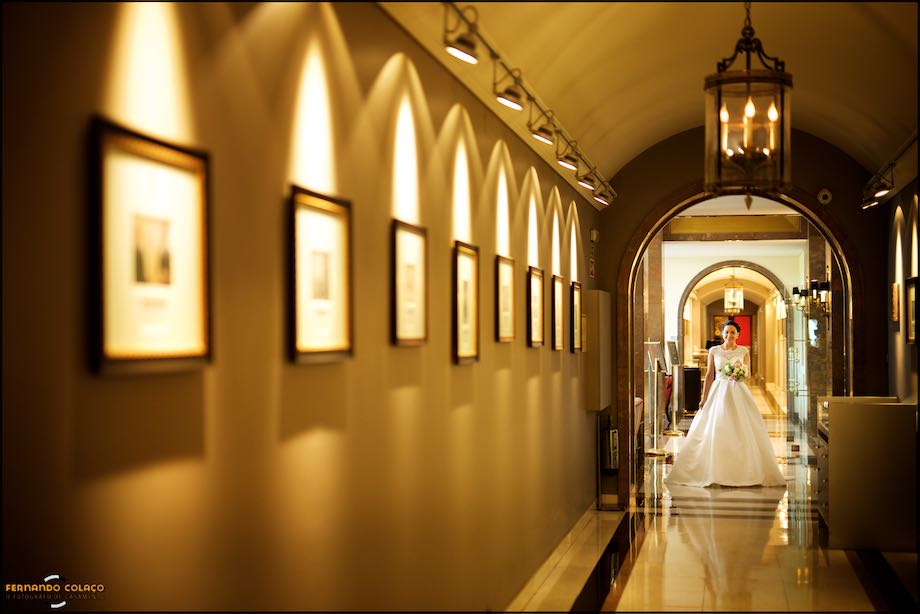 No fundo de um corredor do Palácio Estoril Hotel, a noiva espera para entrar na sala da cerimónia do casamento, captada pelo fotógrafo de casamento em Cascais.