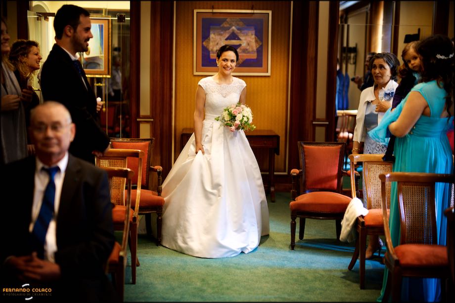 No meio da sala da cerimónia do casamento, a noiva dirige-se para a mesa cerimonial no Palácio Estoril Hotel onde a espera o noivo.