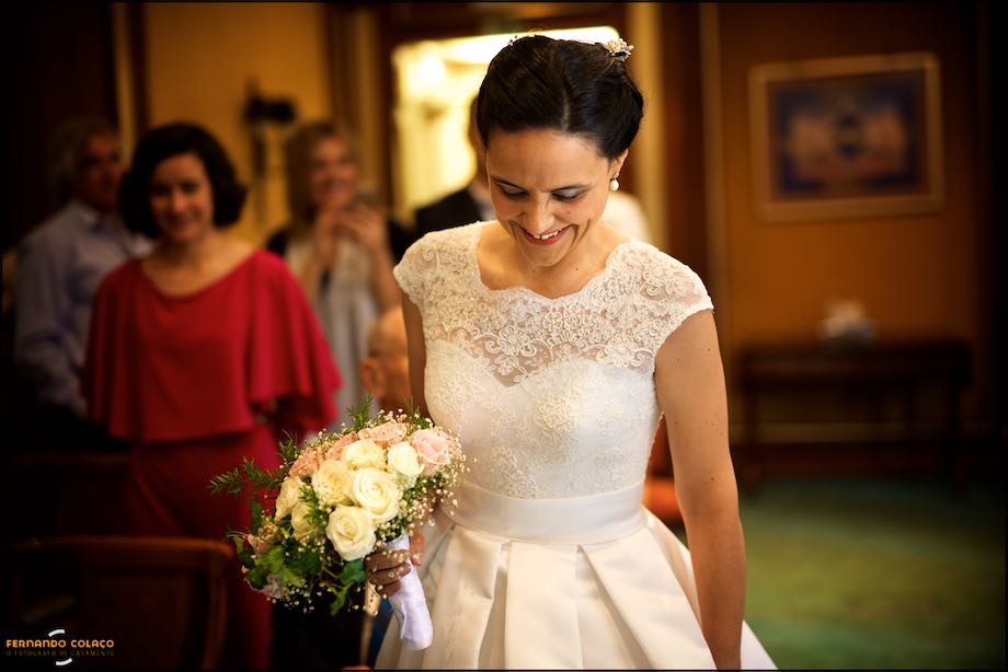 A noiva sorri olhando para baixo, emocionada por ter chegado junto do noivo para a cerimónia do casamento no Palácio Estoril Hotel, pelo fotógrafo de casamento em Cascais.