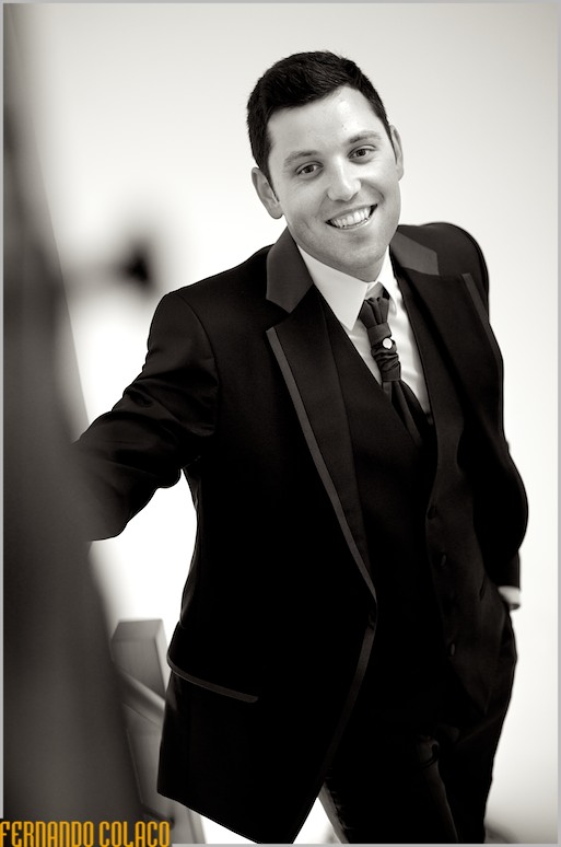 Retrato a preto e branco, ao alto, do noivo, muito feliz a sorrir, momentos antes de partir para a cerimónia.