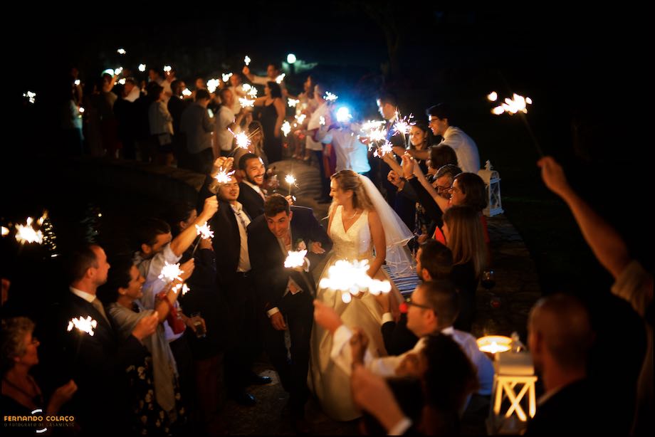 Um universo de luz feito pelos convidados do casamento na Quinta do Castro, no Cadaval, iluminando os noivos a caminho do corte do bolo do casamento, pelo fotógrafo de casamento em Lisboa.