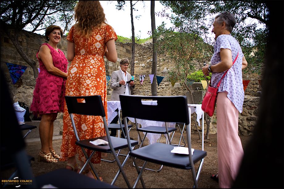 As mães dos noivos e a irmã da noiva em conversa, com o pai do noivo ao fundo, no espaço onde decorrerá a cerimónia.