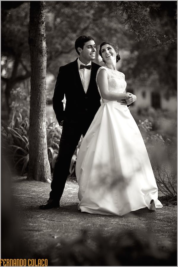 De pé e encostada sobre o ombro do noivo, a noiva olha para ele e sorriem, na sessão com o fotógrafo de casamento em Sintra.