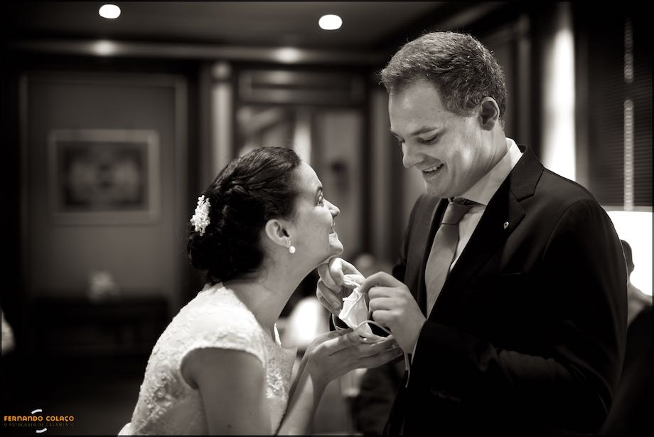 The bride with her hands under the little bag with the rings while the groom takes them off for the ceremony.