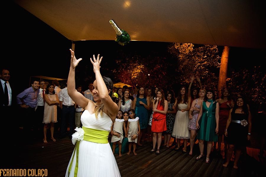 The moment when the bride throws the bouquet, in mid-air, to the single ladies behind her, captured by the wedding photographer in Lisbon.