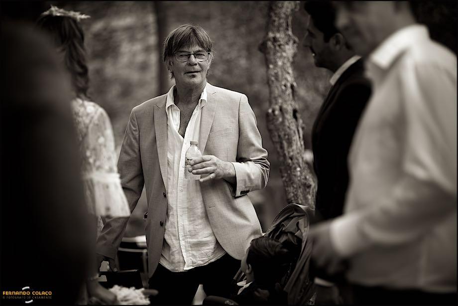 The groom's father in conversation with relatives of the bride during the get-together to make time to go for the meal, captured by the wedding photographer in Lisbon.