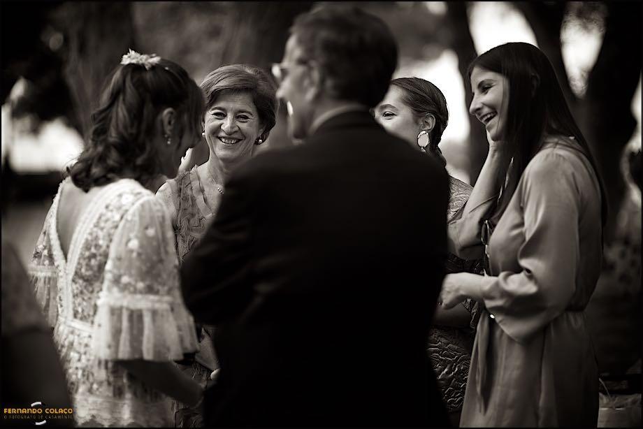 The bride with her family members, parents and sisters, chat fun following the wedding ceremony, seen by the wedding photographer in Lisbon.