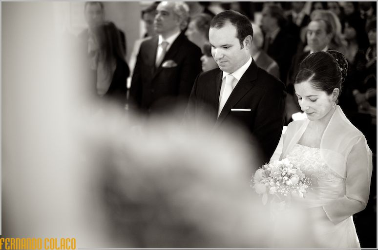 In front of the church altar, the bridal couple in a moment of introspection in a part of the ceremony, was captured by the wedding photographer in Lisbon.