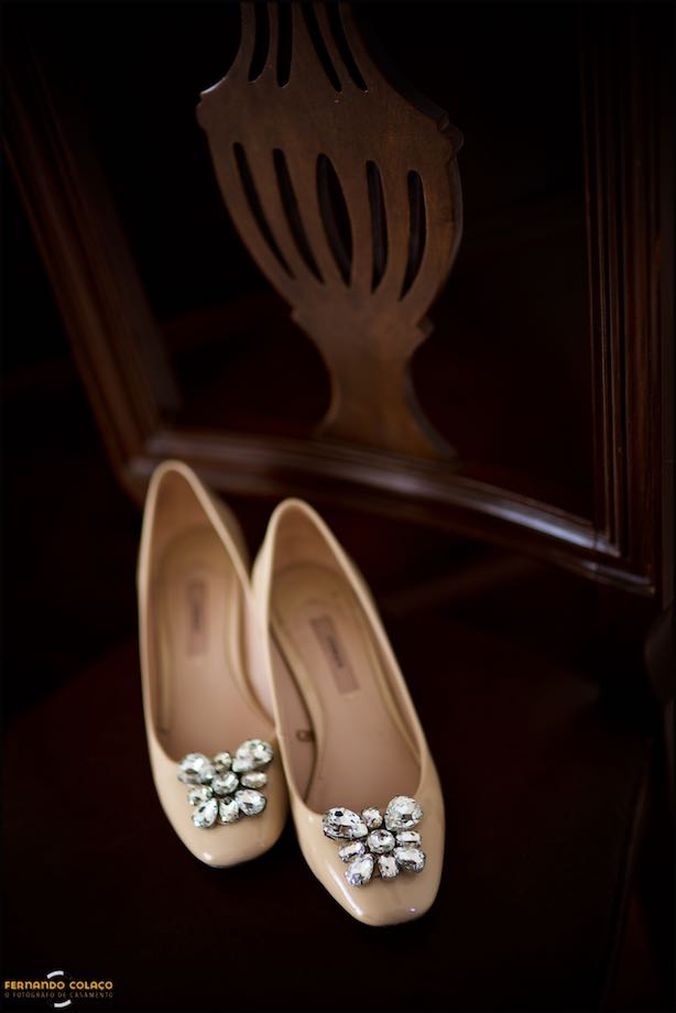 The cream shoes with sparkles of the bride, on an old chair at her parent's house, in a composition made by the wedding photographer in Sintra.