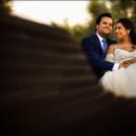 The bride and groom during their session with the wedding photographer, sitting and embracing on a bench in the garden of the Convento do Espinheiro in Évora.