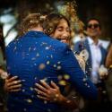 Os noivos abraçam-se sob pétalas de flores quando a acaba a cerimónia do casamento no Castelo de S. Jorge em Lisboa, como os viu o fotógrafo de casamento.