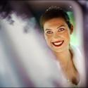 A noiva sorri de dentro do automóvel, por entre reflexos desfocados nos vidros da janela, em composição do fotógrafo de casamento em Lisboa