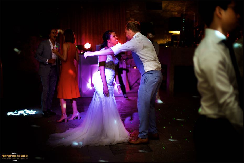 Under the purple light of the Agostos dance floor, the bride and groom dance and chat, as seen by the wedding photographer in the Algarve.