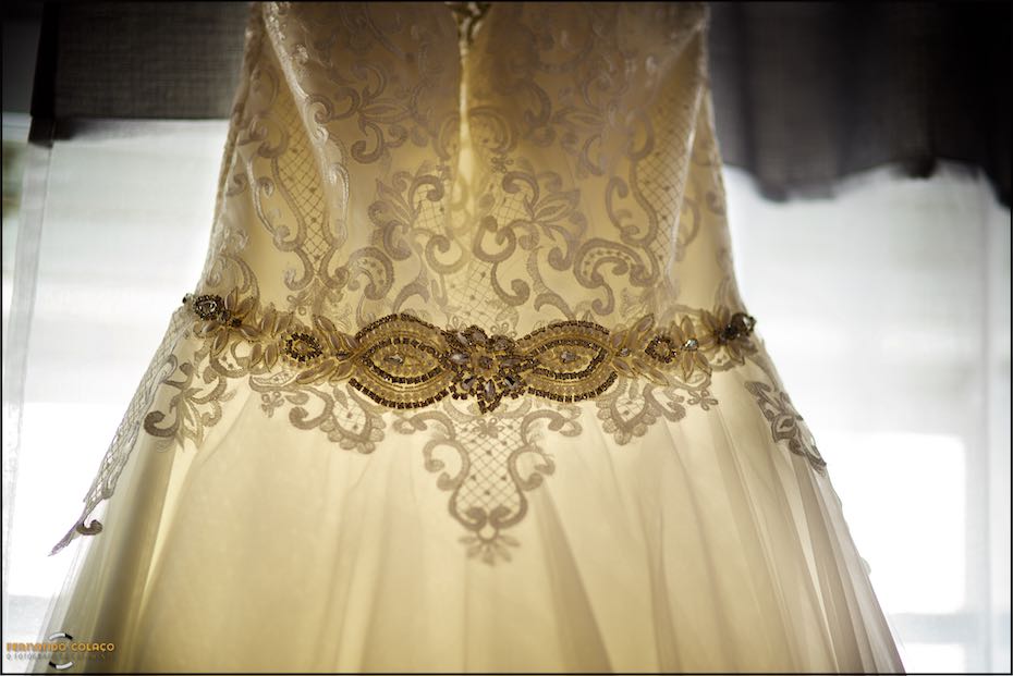 Detail of the lace of the bride's dress with decorative stones, seen by the wedding photographer in Alentejo.