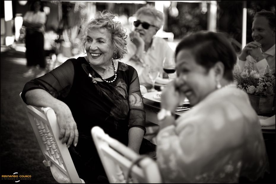 A mãe do noivo rindo-se de uma parte de um discurso durante o jantar nos Agostos, vista pelo fotógrafo de casamento no Algarve.