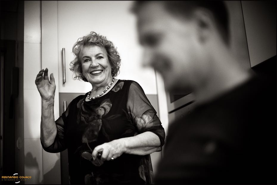 A mãe do noivo conversa com ele, desfocado, muito bem disposta quando se vão prepara para o dia do casamento nos Agostos.