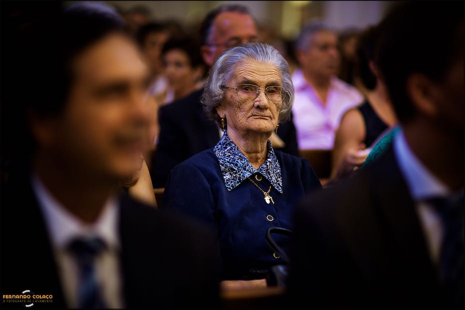 A avó do noivo escuta atentamente o que se passa na cerimónia do casamento na Igreja Matriz de Reguengos de Monsaraz, vista pelo fotógrafo de casamento em Évora.