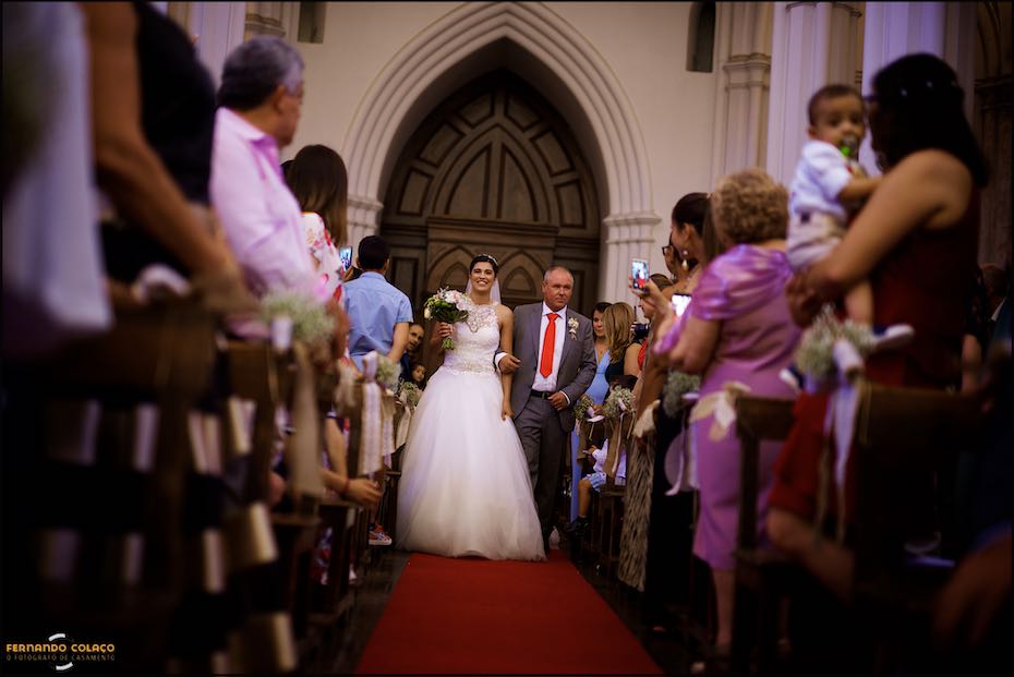 Por entre os convidados, a noiva e o pai percorrem a igreja Matriz de Reguengos de Monsaraz e dar início à cerimónia do casamento.