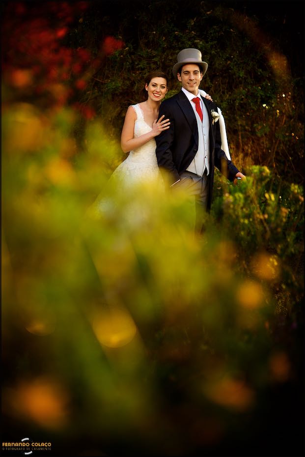 Por entre as flores desfocadas do jardim da Casa de Reguengos, os noivos posam, de frente, para o fotógrafo de casamento em Lisboa.