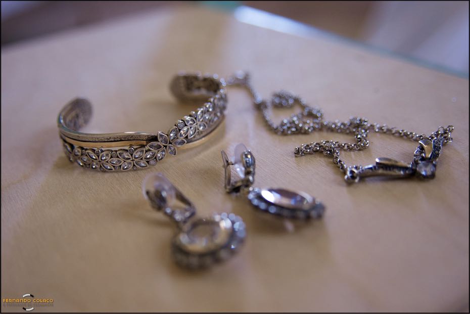 Sobre a tampa de uma caixa branca, uma pulseira, brincos e fio para o pescoço da noiva que vai casar na Quinta do Pé da Serra em Sintra.