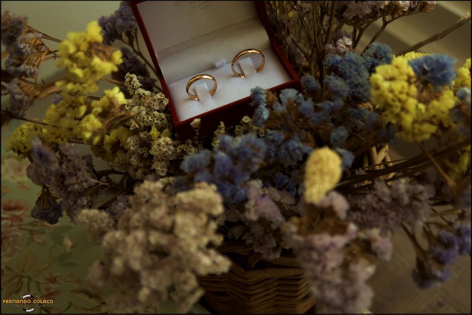As alianças do casamento numa caixa por entre um ramos de flores na Quinta do Pé da Serra em composição do fotógrafo de casamento em Sintra.
