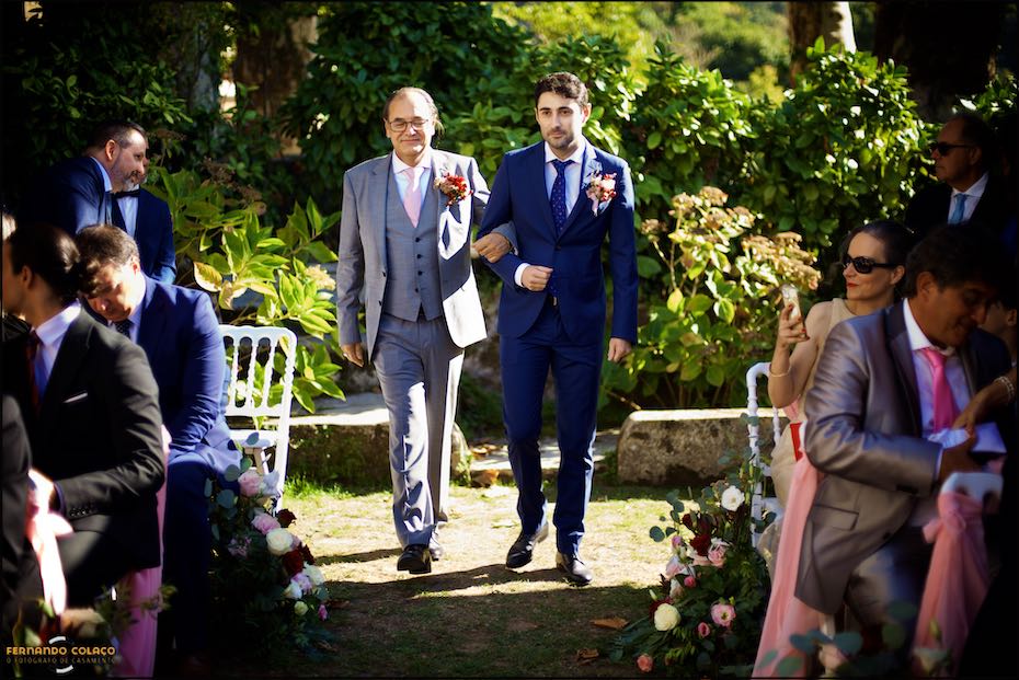 O noivo, com o seu padrinho, caminha por entre os convidados até  à mesa da cerimónia do casamento na Quinta do Pé da Serra em Sintra.