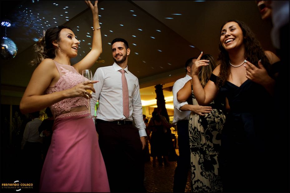 Convidados do casamento cantando e dançando na pista de dança da festa do casamento na Quinta do Pé da Serra em Sintra.