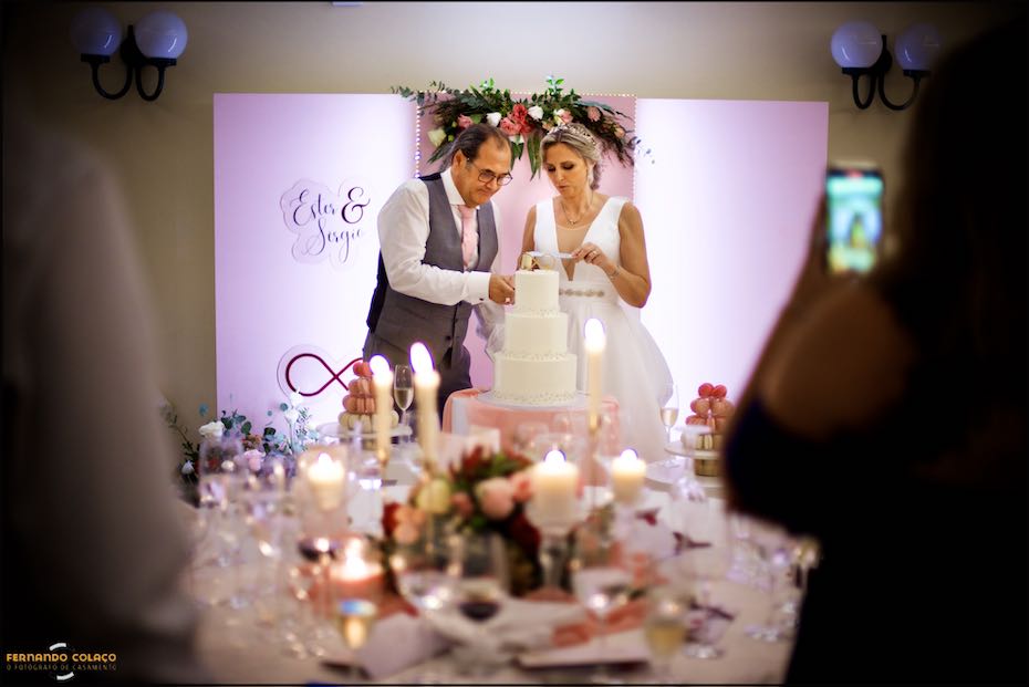 Os noivos cortam o bolo do casamento na Quinta do Pé da Serra em Sintra, numa composição do fotógrafo de casamento.