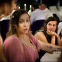 Numa mesa do jantar na Quinta do Pé da Serra, amigas conversam enquanto uma delas escuta a atentamente, conforme as captou o fotógrafo de casamento em Sintra.