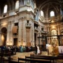 The basilica of Mafra during the wedding ceremony, with the altar, the large side walls and the bride and groom in the background, as seen by the wedding photographer.