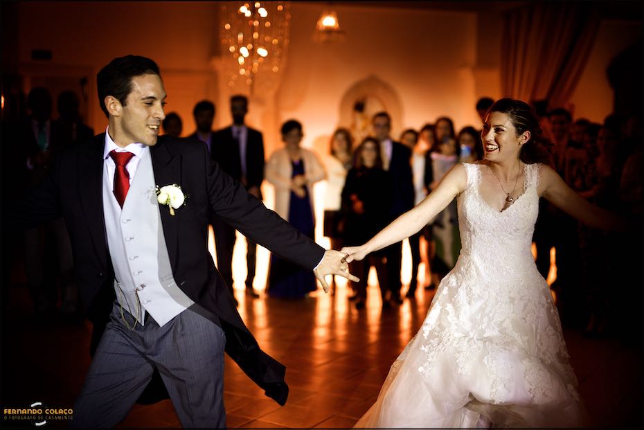 The bride and groom standing next to each other, looking into each other's eyes and holding hands during part of the choreography for the first dance at the opening of the ball at Casa de Reguengos.