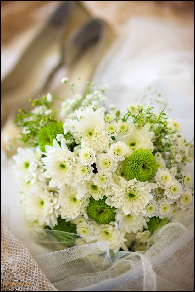 The bride's bouquet waits for her to be ready to go to the ceremony, on a satin box in a composition by the wedding photographer in Seia in the Serra da Estrela, Portugal.