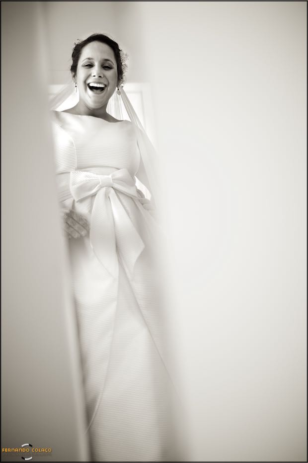 The bride, in the mirror, puts on one of her earrings, seen by the wedding photographer in Seia.