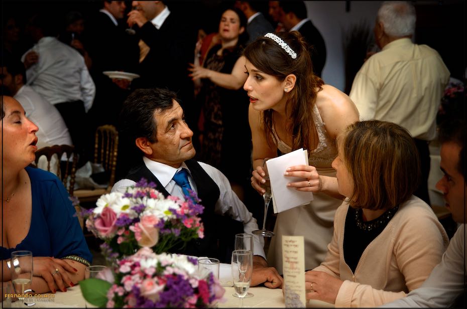 The bride talks to a family of guests during the wedding dinner at Quinta de Nossa Senhora da Serra in Sintra.