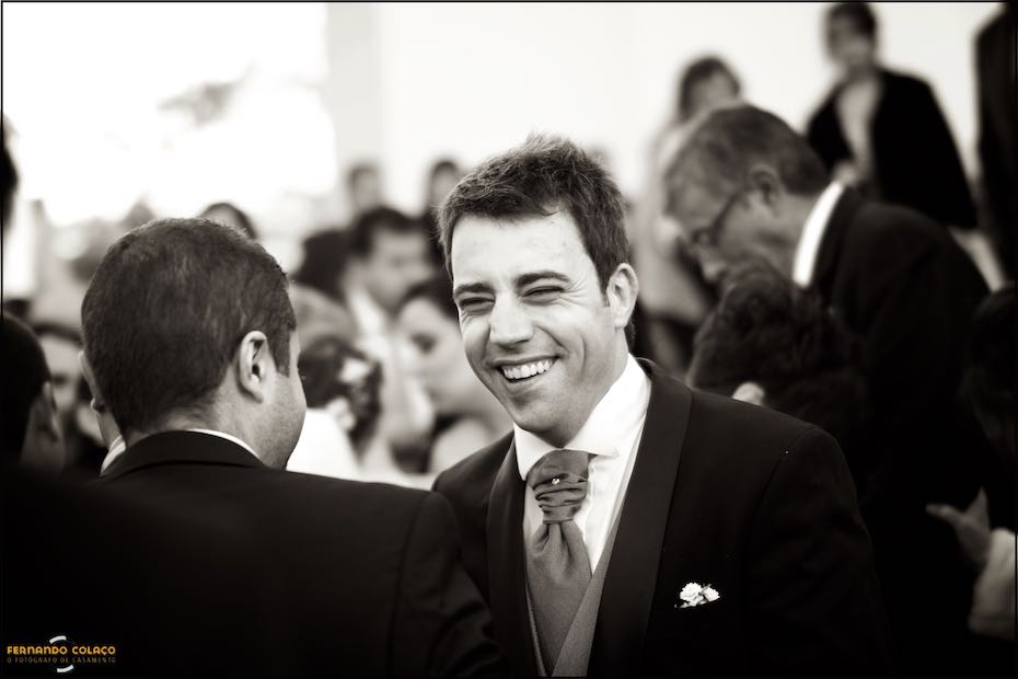 The groom laughing at a guest who congratulates him on the wedding as soon as the ceremony is over.