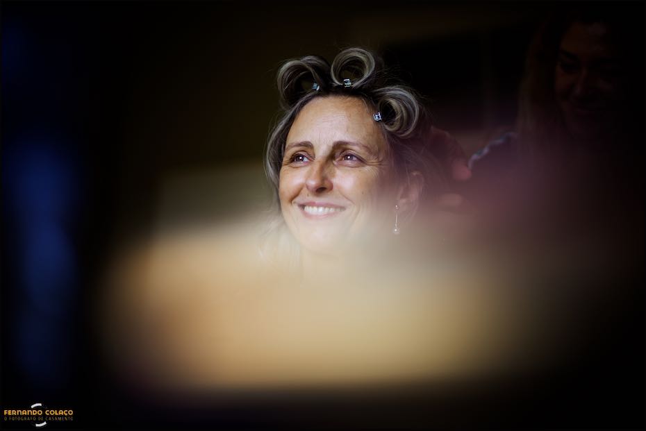 The bride smiles as she is being styled amid blurred colors at Quinta do Pé da Serra.