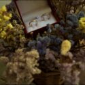 The wedding rings in a box among a bouquet of flowers at Quinta do Pé da Serra in a composition by the wedding photographer in Sintra.