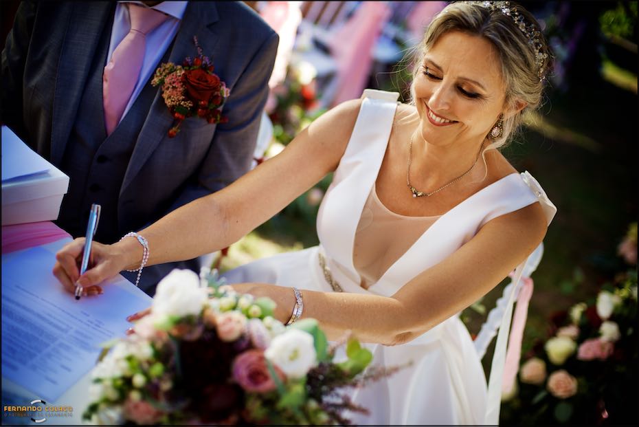 The bride signs the documents for the wedding ceremony at Quinta do Pé da Serra in Sintra.
