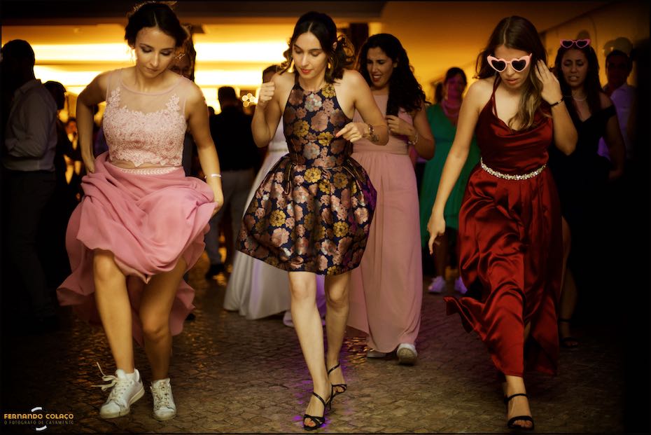 Three wedding guests in front of a choreographed dance at the wedding party at Quinta do Pé da Serra in Sintra.