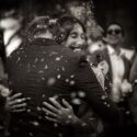 After the wedding ceremony, the bride and groom hug each other full of joy, surrounded by flower petals, as captured by the wedding photographer in Lisbon.